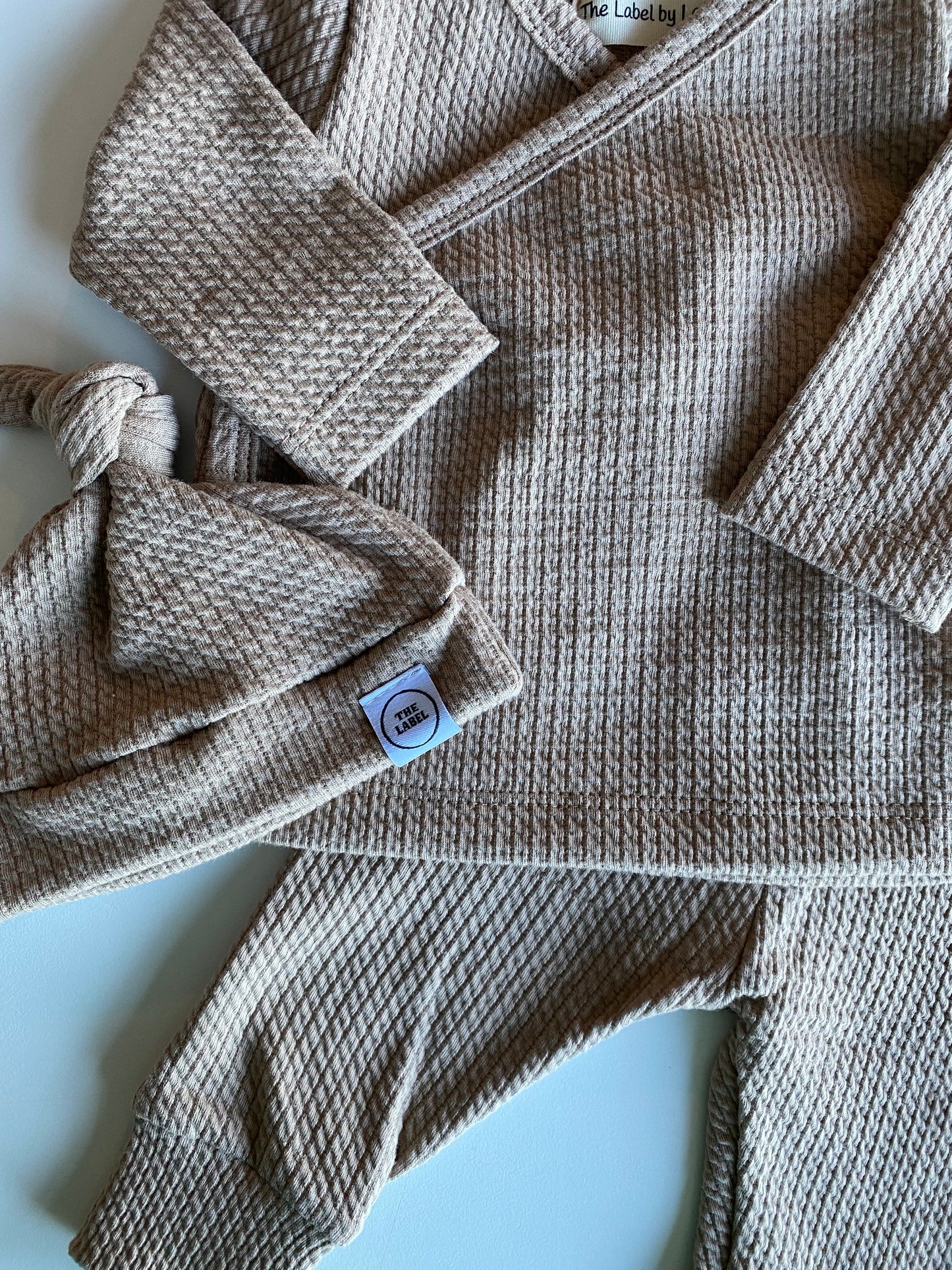 Knoopmutsje kabel donker beige