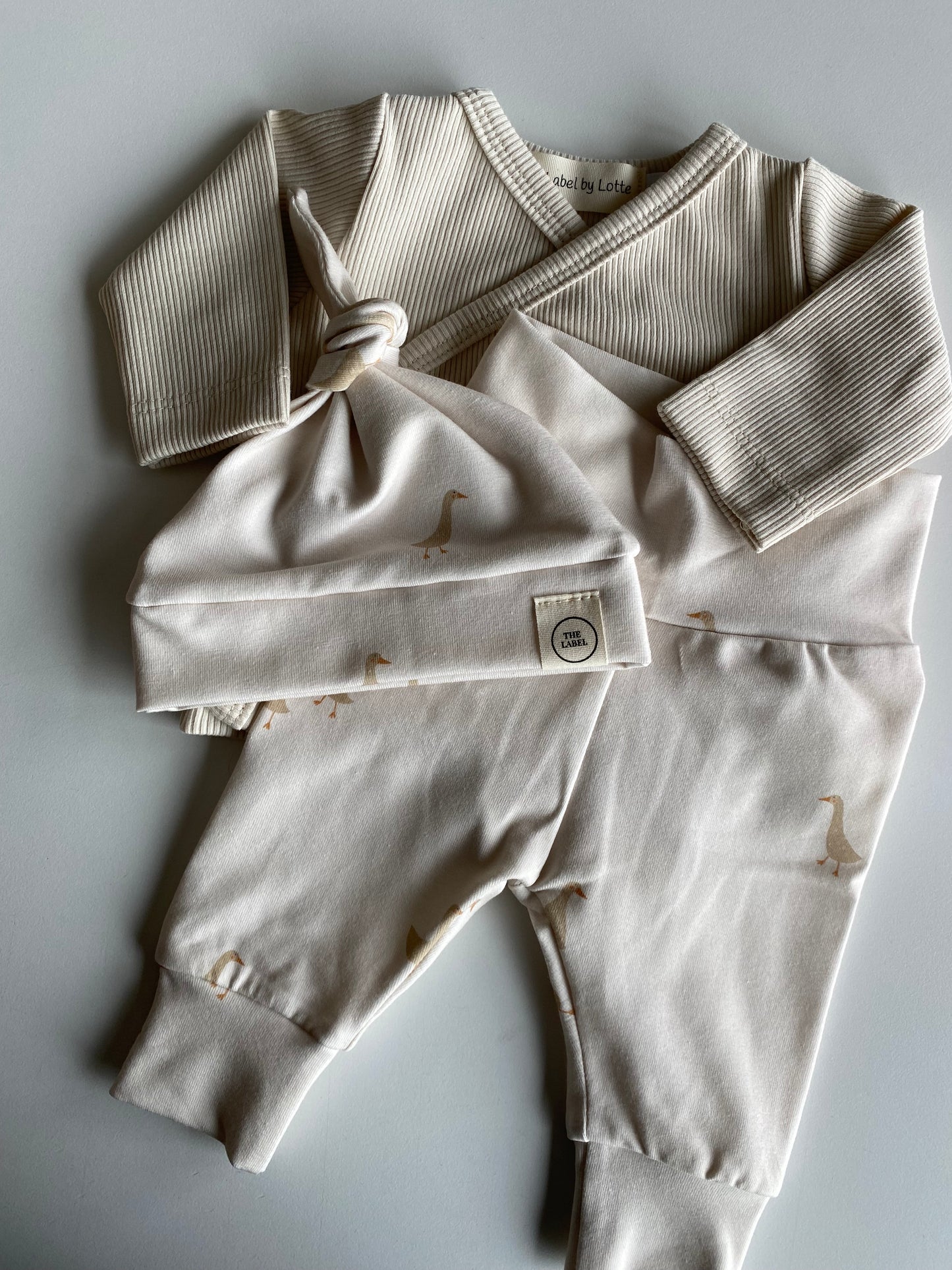 Uniseks newborn set gansjesprint beige – broekje & knoopmutsje