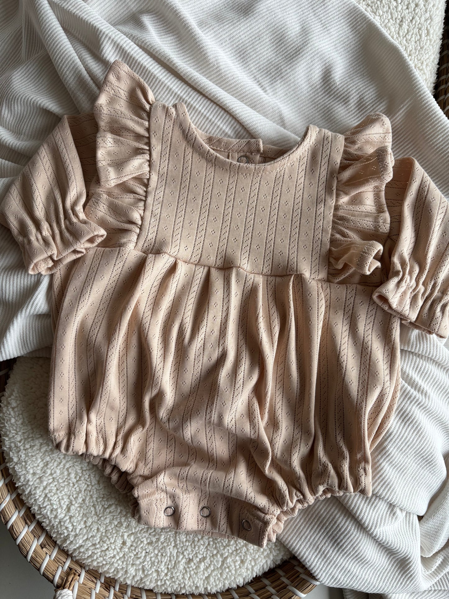 Handgemaakte romper/playsuit  met lange mouw en ruffle met ajour werkje. Gemaakt van 100% katoen.